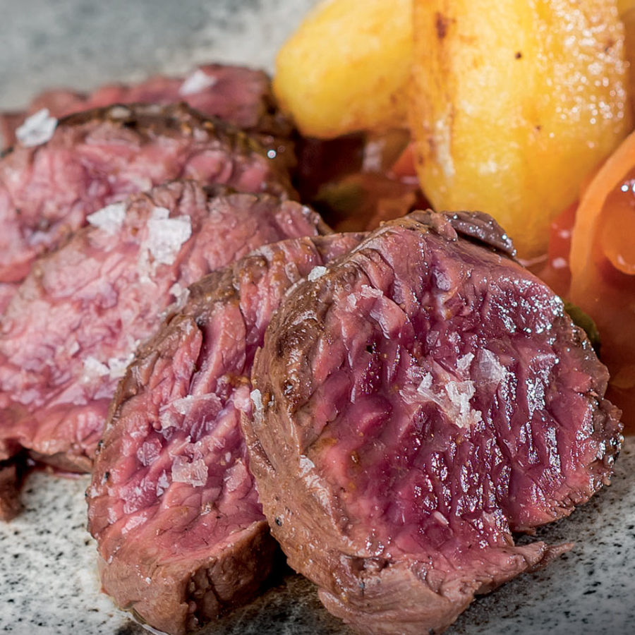 Onglet de bœuf poêlé au beurre, pommes de terre gueulantes, condiments tomates, oignons et cornichons